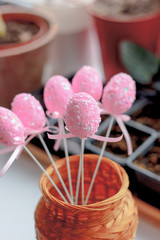 Pink easter eggs on a sticks over the bright background.