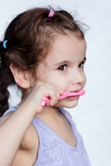 Adorable child girl cleaning teath by toothbrush.