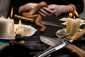 The snake crawls to the table in front of the witch