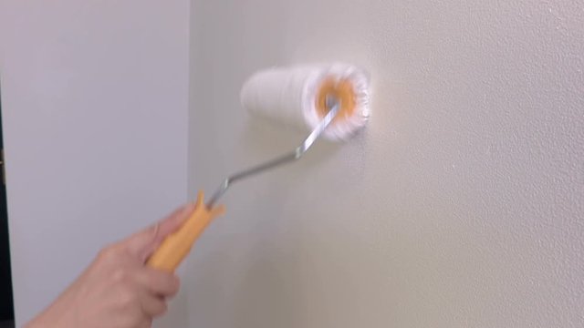Paint roller brush moving on wall