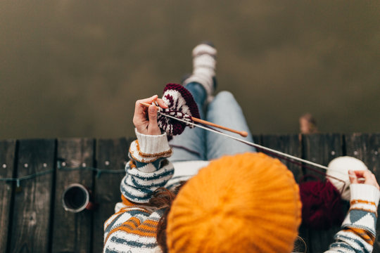 Crop woman knitting with wool