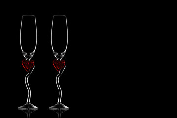 Two silhouettes of glasses for champagne on a black isolated background