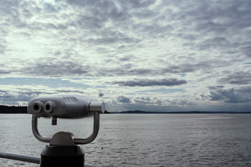 View binoculars on the Seattle waterfront under late afternoon clouds 