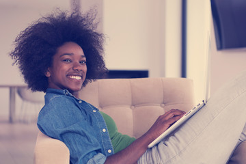 African American women at home in the chair using a laptop