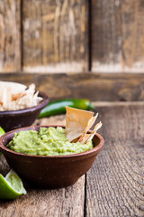 Fresh guacamole dip with lime juice and handmade nachos