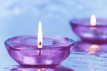 Candles in candlesticks on a metallic close-up background in purple