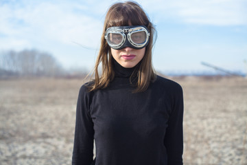 Young woman with sand goggles standing alone and posing