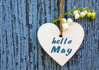 Hello May greeting card with decorative white heart and lily of the valley flower on old blue wooden background.Springtime concept.
Selective focus.