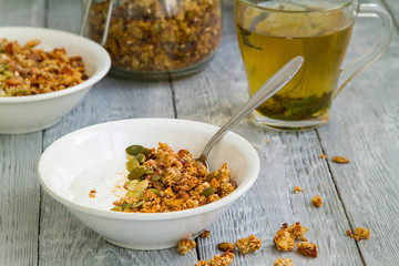 Granola Breakfast with yogurt in a plate and herbal tea