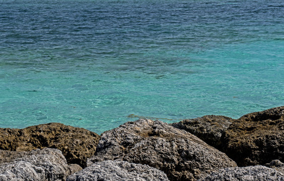 A rock bed and the natural turquoise waters of the Bahamas.