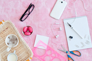 coffee mug cappuccino blaknot with a pen and smartphone on a pink background. concept of the beginning of the working day, business concept