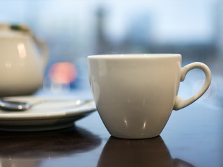 White cup on the table, breakfast in a cozy cafe