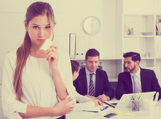 Unhappy woman at office with coworkers