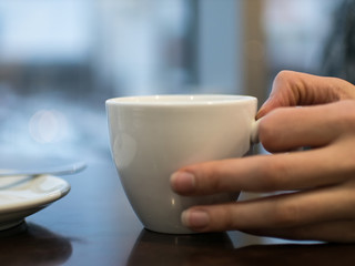 White cup on the table, breakfast in a cozy cafe