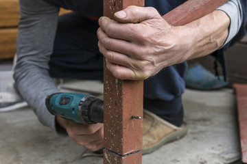 worker drilling drill metal with red detail