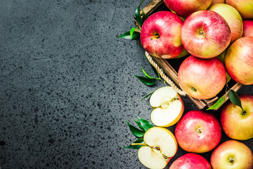 Raw apples in wooden box on concrete background. Top view, space for text.