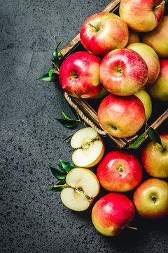 Raw apples in wooden box on concrete background. Top view, space for text.