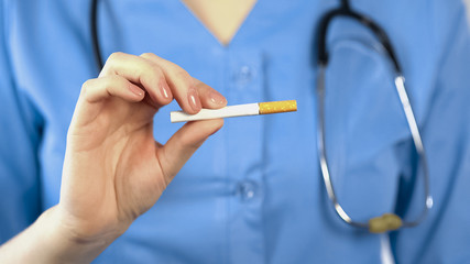 Female therapist showing cigarette, warning about health hazards of smoking