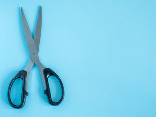 Open a large pair of scissors on a blue background