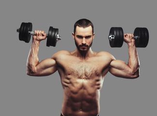 Plakat A Muscular guy working out with dumbbells. Isolated on a gray ba
