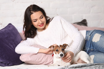 Girl lying on the bed with her puppy. Photographie retouchee