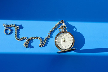 Vintage pocket watch on blue background
