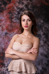 Fototapeta na wymiar Fashion photo of a beautiful young woman in a pretty dress posing over marble colored background. Fashion photo