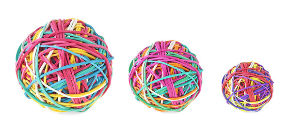 Three colorful balls of rubber bands on a white background