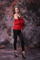 Fototapeta premium Thin Woman with red jacket standing on over marble colored background. Fashion photo.