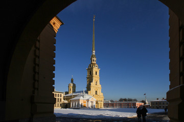 Fototapeta na wymiar Winter day in St. Petersburg. The main attraction of St. Petersburg fortress in the city center - Peter and Paul. The spire of Peter and Paul Cathedral shines in the sun.