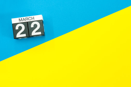 March 22nd. Day 22 of march month, calendar on blue and yellow background flat lay, top view. Spring time. Empty space for text