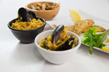 Fried fish and rice with mussels on dish with lemon and salad. Typical sicilian food