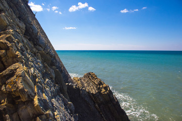 rocky sea shore with pebble beach, waves with foam