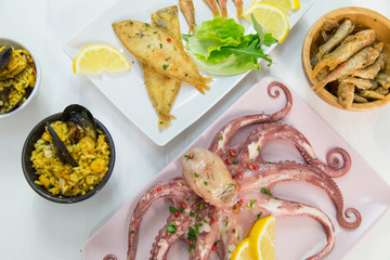 Fried fish,rice with mussels and octopus on dish with lemon and salad. Typical sicilian food