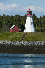 Fototapeta na wymiar Canadian Lighthouse On Rocky Coast During Low Tide