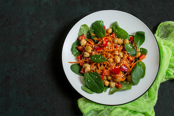 Vegetarian salad with chickpea, carrot, sweet pepper and spinach