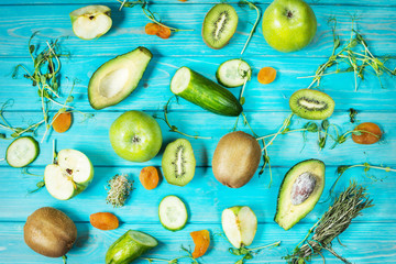 Ingredients for cooking smoothie. Organic green vegetables and fruits on blue wood background. Flat lay