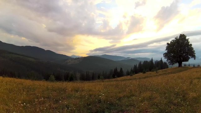 Beautiful countryside scenery with dramatic cloudy sky and mountains range, time lapse