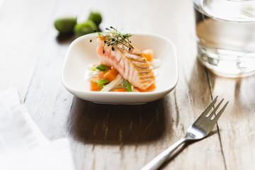 fresh little salad with salmon and sprouts on wooden table