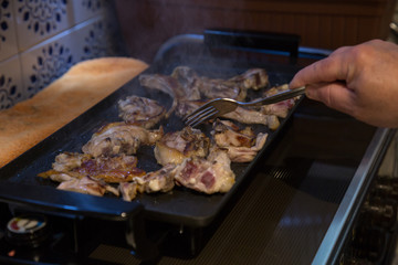 Senior man making grilled lamb chops at home. 