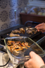 Senior man making grilled lamb chops at home. 