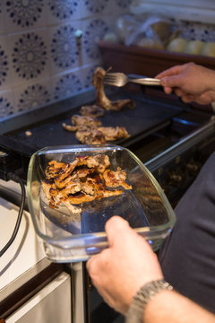 Senior man making grilled lamb chops at home. 