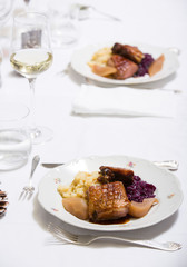 Elegant white laid table with dinner, glass with white wine