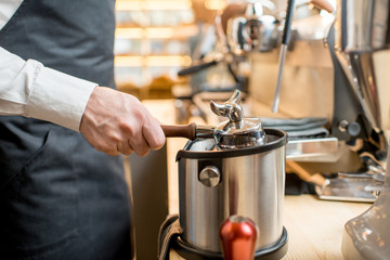 Beating handle of a professional coffee machine taking off a remains of coffee