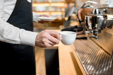 Barista making coffee with professional coffee machine in the cafe