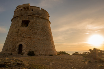 Fototapeta na wymiar Medieval tower of Sal Rossa at sunrise in Ibiza