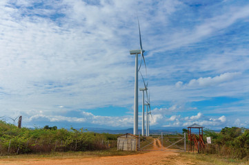 Fototapeta na wymiar group of Wind power stations side view on blue sky background