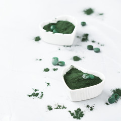 Superfood concept ground green spirulina algae powder, pills tablets