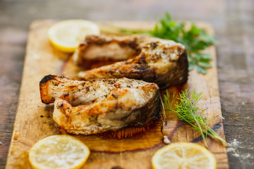 appetizing grilled fish pieces with parsley on the board