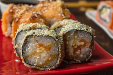 Set of Sushi Roll in tempura on ceramic plate, macro photo. Japanese seafood